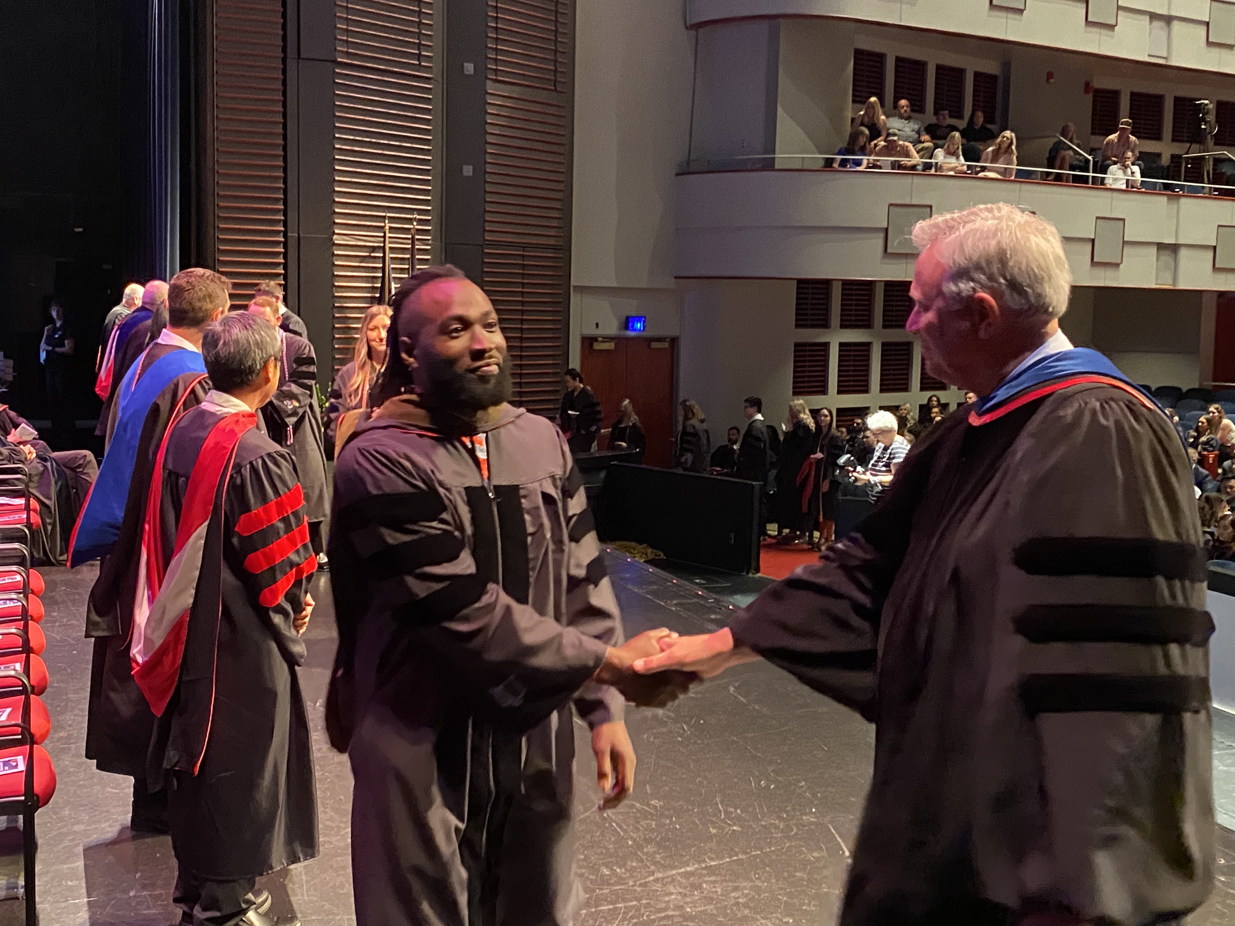 KU Pharmacy Dean Ronald Ragan shakes the hand of a Class of 2022 graduate during commencement