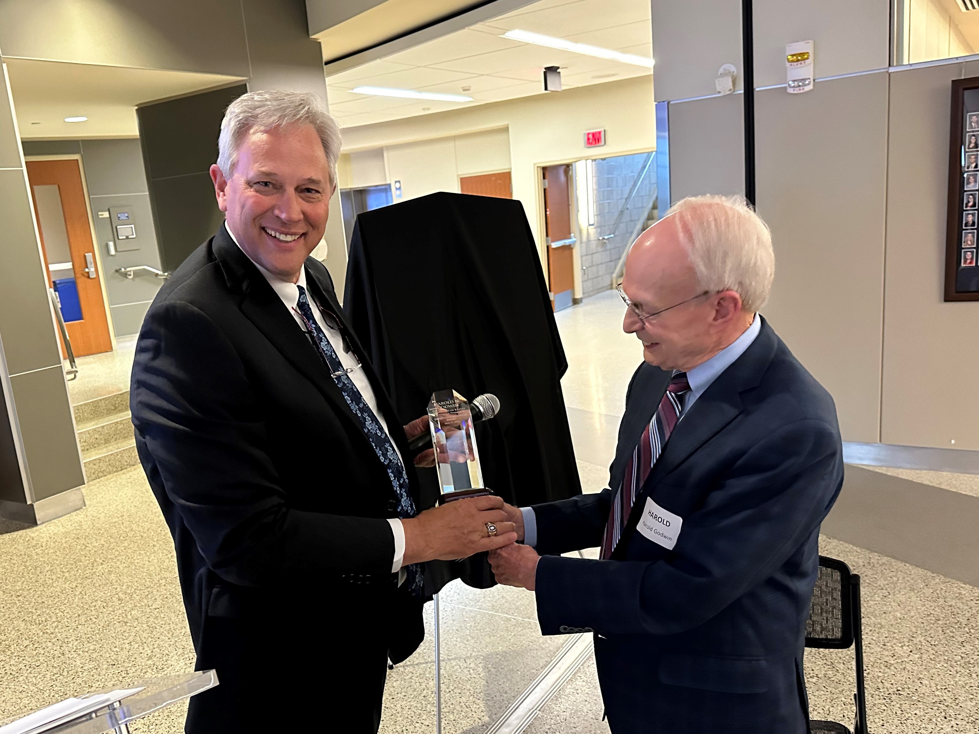 Dean Ronald Ragan presents the Distinguished Service Award to professor emeritus Harold Godwin.